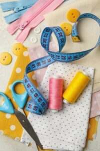 Sewing supplies on white background, top view